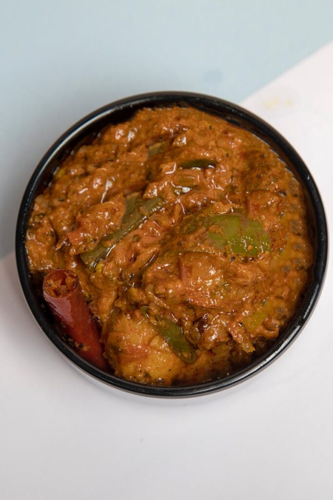Top-down view of flavorful Indian vegetable curry in a black bowl, perfect for food presentations.
